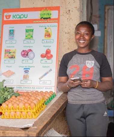 visual of lady standing in a shop besides eggs and Kapu poster