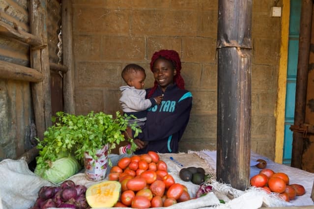 Visual of woman carrying a baby in her grocery shop